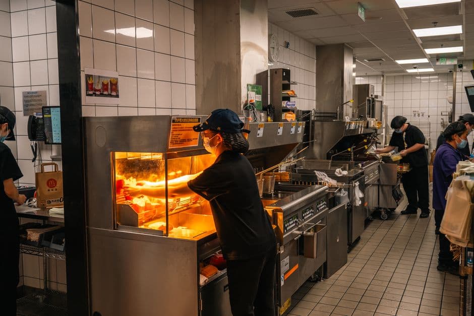 Modern fast food restaurant kitchen interior with staff preparing orders